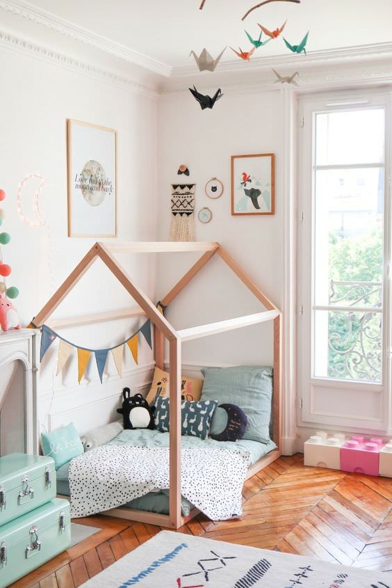 اتاق خواب کودک که دارای تخت چوبی شیروانی و کفپوش چوبی می باشد و سقف آن با اوریگامی های پرنده درنا تزیین شده است